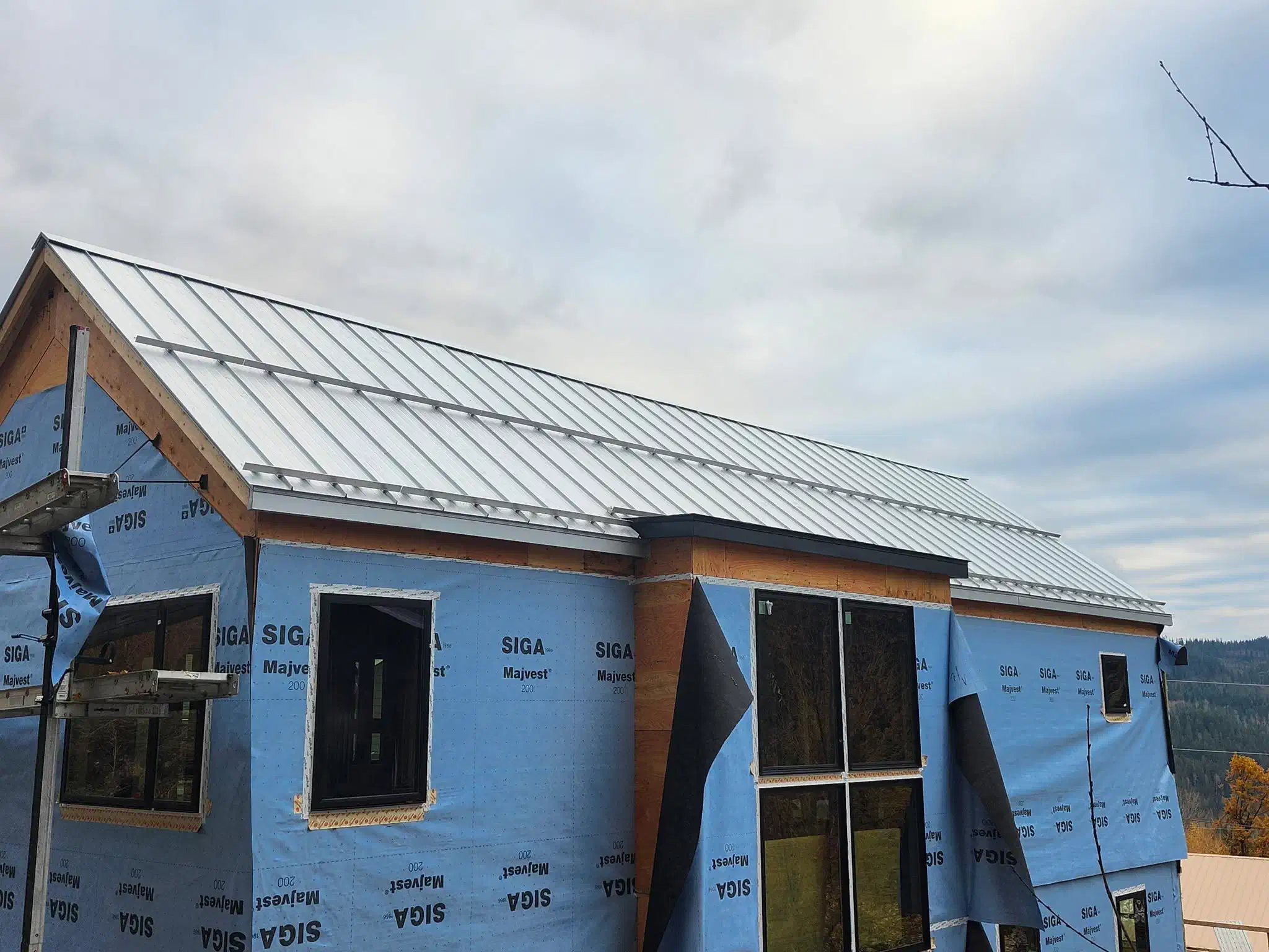 Standing seam steel roof spanning a new custom home — West Kootenays