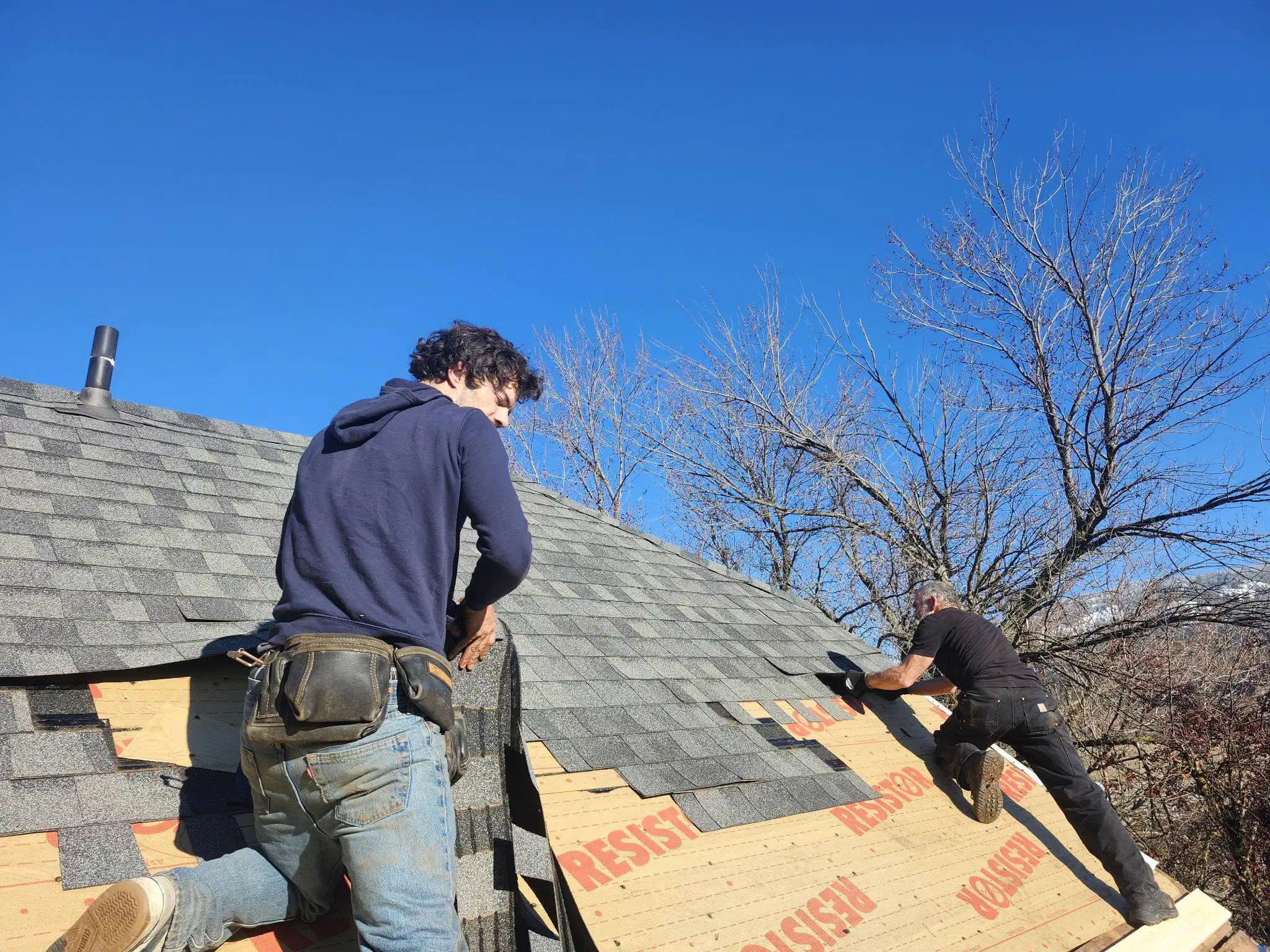 Trail Roofing crew installing architectural shingles on a steep roof — West Kootenays