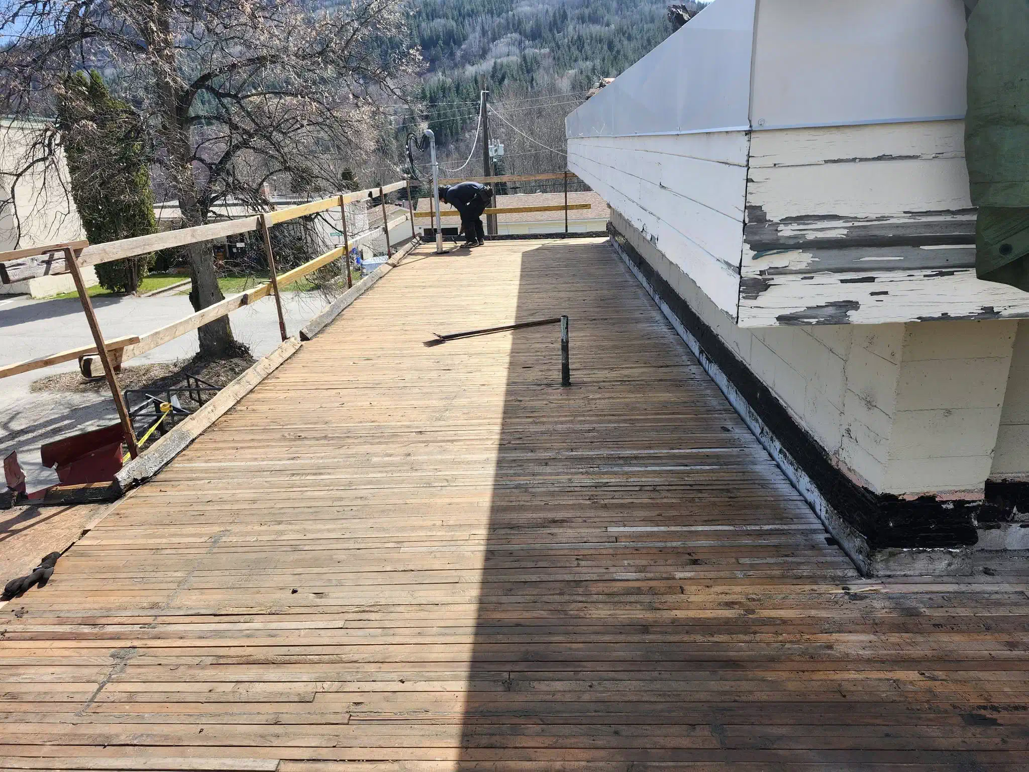 Flat roof torn off to the original wood plank deck before re-roofing — West Kootenays