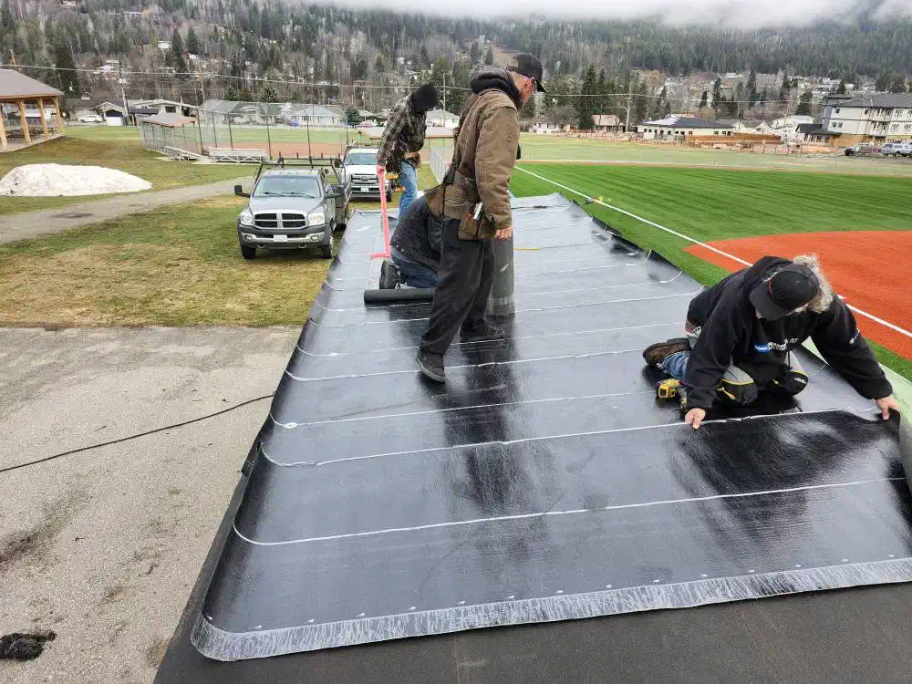 Trail Roofing crew installing torch-on membrane on a flat roof — West Kootenays